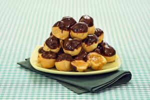 Profiteroles ausgestopft und bedeckt im Schokolade Soße foto