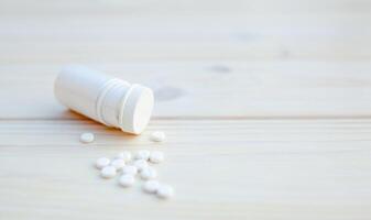 Tabletten und Pille Flasche auf Weiß hölzern Hintergrund foto
