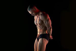 aktiv Lebensstil Konzept. Fachmann Bodybuilder zeigen perfekt muskulös Körper, Lampen Erleuchtung auf Hintergrund foto
