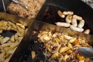 geröstet Kartoffeln gekocht draußen im groß Metall Kessel Topf. Straße schnell Essen foto