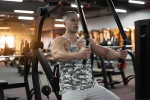 muskulös sportlich Bodybuilder Sitzung Bank Ausbildung Truhe Muskeln auf Fitness Ausrüstung foto