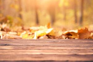 leeren hölzern Tabelle Herbst Blätter Natur Bokeh Hintergrund mit ein Land draussen Thema, Vorlage spotten oben zum Anzeige von Produkt foto