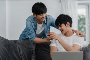 junges asiatisches schwules paar schlagen in einem modernen haus vor, jugendlich koreanische lgbtq-männer, die glücklich lächeln, haben eine romantische zeit, während sie vorschlagen und heiratsüberraschung tragen ehering im wohnzimmer im hauskonzept. foto