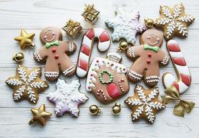 Weihnachtslebkuchen mit Weihnachtsschmuck auf weißem Holz foto