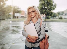 begeistert ernst schön jung Mädchen halten Stapel von Bücher Stehen in der Nähe von Campus Lebensstil Positivität akademisch Abschluss Universität Schule foto