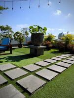 Surakarta, Indonesien, 2023 - - ein Grün Garten beim das Dach mit das Platz Stein Fliesen foto