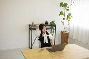 ein entspannt japanisch Frau durch Fernbedienung Arbeit im das klein Büro foto