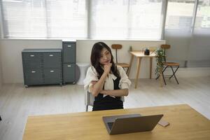 ein besorgt japanisch Frau durch Fernbedienung Arbeit im das klein Büro foto