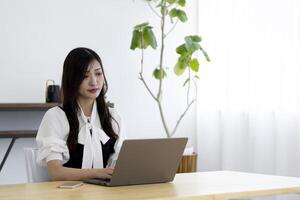 ein Arbeiten japanisch Frau durch Fernbedienung Arbeit im das Zuhause Büro Nahansicht foto