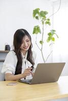 ein Arbeiten japanisch Frau durch Fernbedienung Arbeit im das Zuhause Büro Nahansicht foto