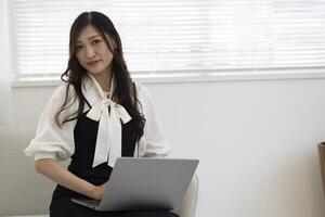 ein Arbeiten japanisch Frau durch Fernbedienung Arbeit im das Zuhause Büro Nahansicht foto