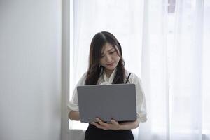 ein Arbeiten japanisch Frau durch Fernbedienung Arbeit im das Zuhause Büro Nahansicht foto