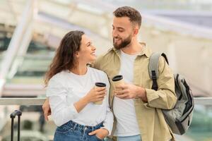 entspannt Paar Trinken wegbringen Kaffee während warten zum Flug beim Flughafen foto