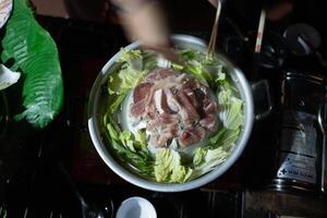 roh Schweinefleisch auf ein heiß braten Pfanne, Essen, ein Beliebt Essen unter thailändisch Menschen auf Ferien foto