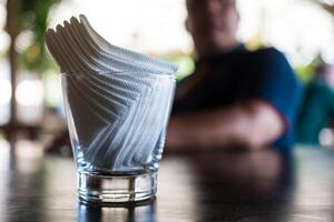 selektiv Fokus auf Weiß Papier Gewebe im Glas auf Holz Tisch. foto