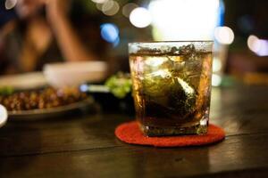 ein Glas von Whiskey auf Holz Tisch. foto