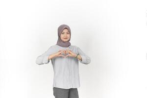 jung asiatisch Frau tragen Hijab zeigen Liebe Herz Zeichen isoliert auf Weiß Hintergrund foto