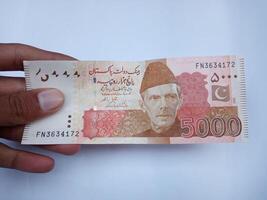 pakistanisch 5000 Hinweis halt im Hand, isoliert auf Weiß Hintergrund. foto