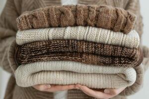 ai generiert gemütlich Hände ruhen auf ein Stapel von warm gestrickt Pullover foto