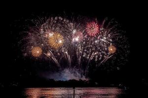 feuerwerk auf dem fluss im dunklen himmel foto