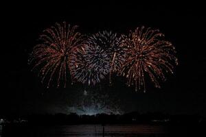 feuerwerk auf dem fluss im dunklen himmel foto