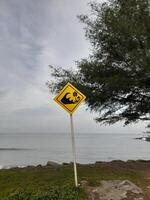 Zeichen Warnung von das Achtung von groß Wellen platziert in der Nähe von das Strand auf das Insel von Lombok, Indonesien foto