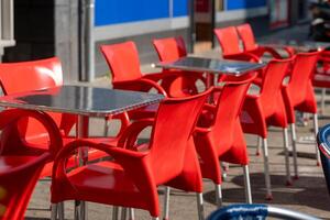 Reihe von rot Stühle und Tabellen sind einstellen oben draußen foto