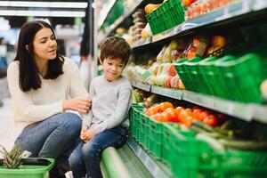 Frau und Kind Junge während Familie Einkaufen mit Wagen beim Supermarkt foto