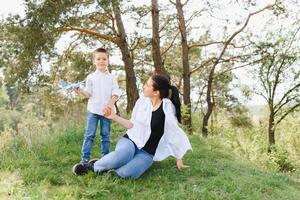 glücklich jung Mutter ist spielen mit ihr Baby im ein Park auf ein Grün Rasen. Glück und Harmonie von Familie Leben. großartig Familie Urlaub. gut Wochenende. Mütter Tag. Urlaub. das Konzept von ein glücklich Familie foto