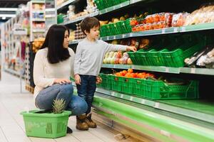 Frau und Kind Junge während Familie Einkaufen mit Wagen beim Supermarkt foto