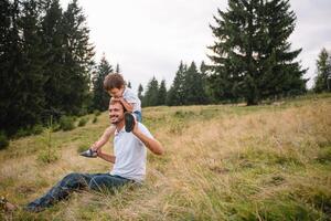 Vater und Kind Wandern im szenisch Berge. Papa und Sohn genießen das Aussicht von das Berg oben im Karpaten Berge foto