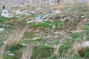 ökologisch Verschmutzung von Natur. Plastik Tasche verheddert im Pflanzen gegen das Hintergrund von das Berge. global Umwelt Verschmutzung. Recycling, Clearing das Land von Plastik Trümmer. foto