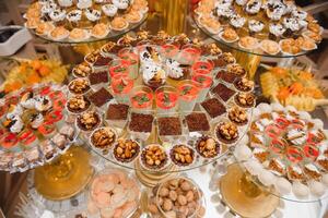 Nachspeisen mit Früchte, Mousse, Kekse. anders Typen von Süss Gebäck, klein bunt Süss Kuchen, Makronen, und andere Nachspeisen im das Süss Büfett. Süßigkeiten Bar zum Geburtstag foto