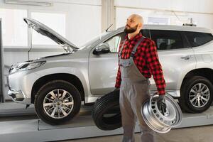 Mechaniker Arbeiten und halten Schlüssel von Bedienung bestellen zum Aufrechterhaltung Auto beim das Reparatur Geschäft foto