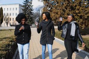 stilvoll afrikanisch amerikanisch Mädchen Trinken Kaffee auf das Straße foto