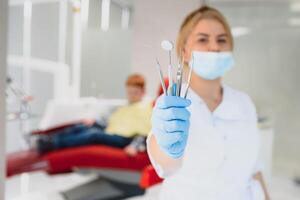 Porträt von ein Zahnarzt halten Dental Instrumente im seine Hände im das Klinik Nahansicht foto