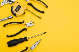 Gelb und schwarz praktisch Werkzeuge Piler und Schraubendreher isoliert auf Gelb Hintergrund. foto