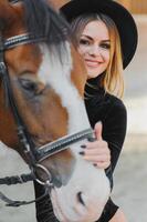 Porträt von jung ziemlich heiter Frau mit Pferd beim Sommer- foto