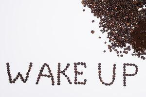 Wörter aufwachen oben von Kaffee Bohnen isoliert auf Weiß Hintergrund foto