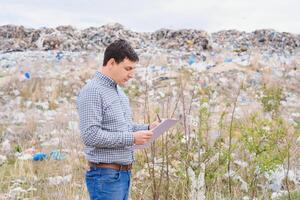Natur Erhaltung Konzept. ein Mann Studien das Verschmutzung von Natur. behalten das Umgebung sauber. ökologisch Probleme. Recycling foto