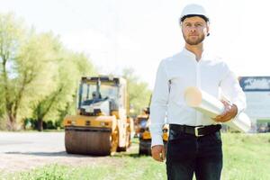 Ingenieur in der Nähe von Straße Maschinen. das Konzept von Gebäude ein Neu Asphalt Straße. Straße Reparatur. Straße Bedienung Arbeiter in der Nähe von das Eisbahn. foto