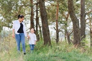 glücklich jung Mutter ist spielen mit ihr Baby im ein Park auf ein Grün Rasen. Glück und Harmonie von Familie Leben. großartig Familie Urlaub. gut Wochenende. Mütter Tag. Urlaub. das Konzept von ein glücklich Familie foto