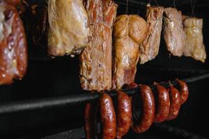 geräuchert traditionell geräuchert Fleisch. ein Komposition von geräuchert kalt schneidet auf ein schwarz Hintergrund. foto