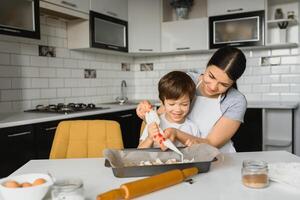 glücklich Familie. Mutter Lehren ihr Sohn Wie zu Kochen Kuchen Speisekarte im Morgen. gesund Lebensstil Konzept.. Backen Weihnachten Kuchen und Koch Konzept foto