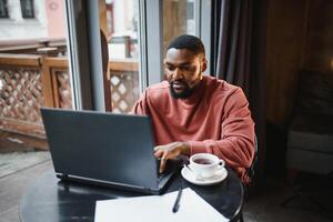 Geschäftsmann mit Telefon Arbeiten auf Laptop im Kaffee Geschäft. foto