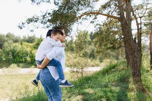 stilvoll Mutter und gut aussehend Sohn haben Spaß auf das Natur. glücklich Familie Konzept. Schönheit Natur Szene mit Familie draussen Lebensstil. glücklich Familie ruhen zusammen. Glück im Familie Leben. Mütter Tag. foto