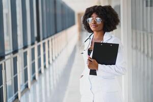 schön afrikanisch amerikanisch weiblich pädiatrisch Krankenschwester im modern Büro foto