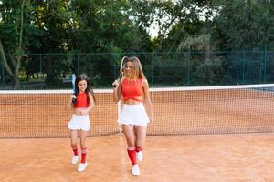 Mutter und Tochter üben Tennis foto