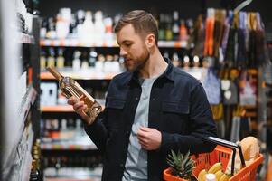 Mann im ein Supermarkt wählen ein Wein foto