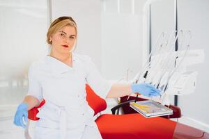 Menschen, Medizin, Stomatologie und Gesundheitswesen Konzept - - glücklich jung weiblich Zahnarzt mit Werkzeuge Über medizinisch Büro Hintergrund foto